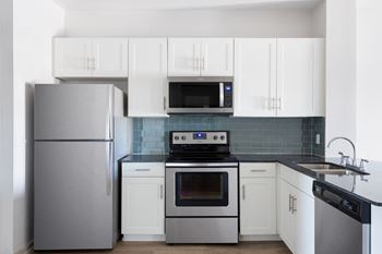a kitchen with stainless steel appliances and white cabinets